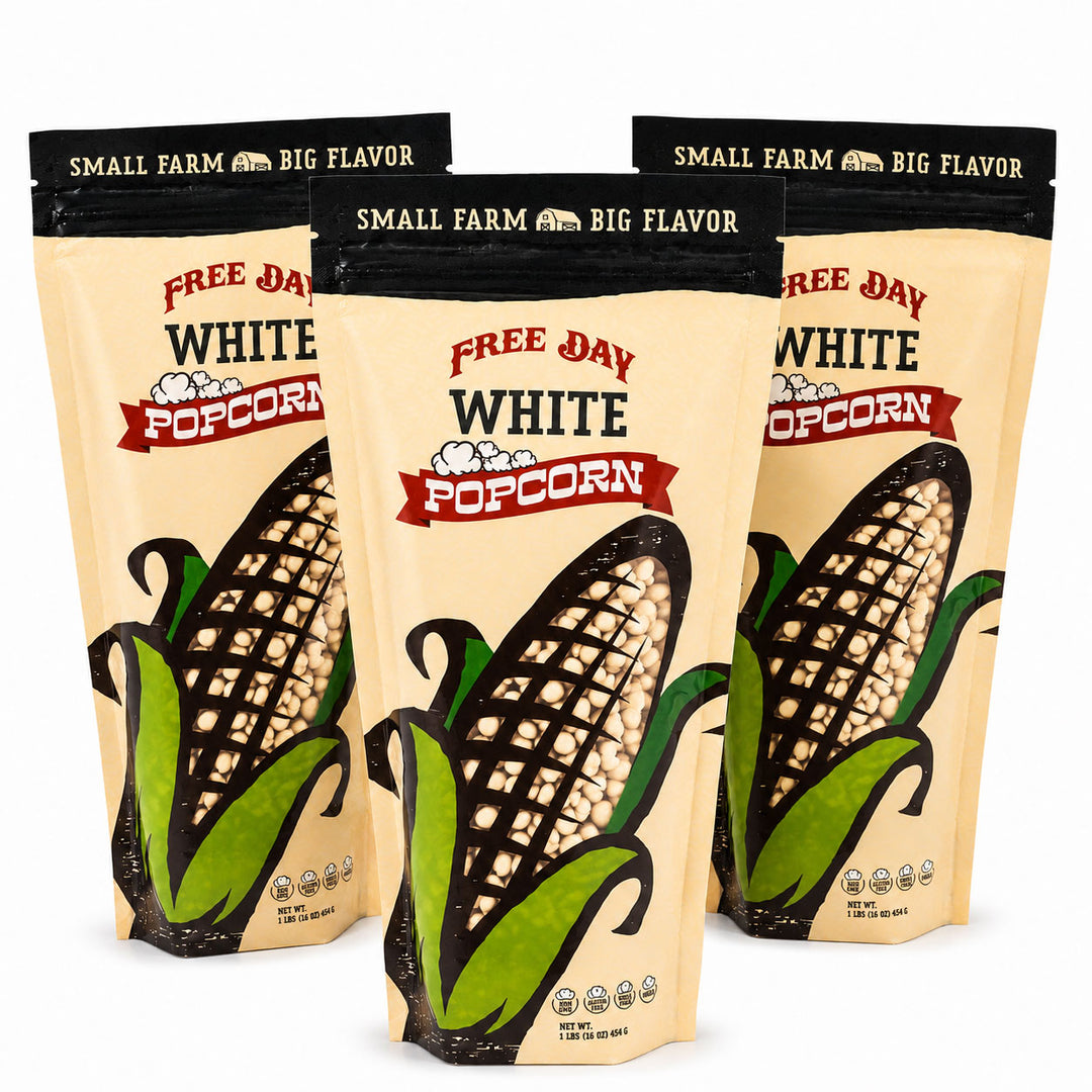 Three bags of Free Day White Popcorn with corn illustrations on a white background