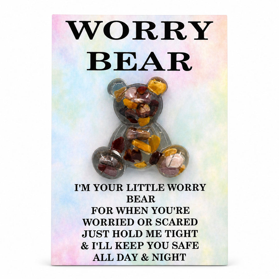 Decorative brooch shaped like a bear with colorful stones on a pastel background with text.