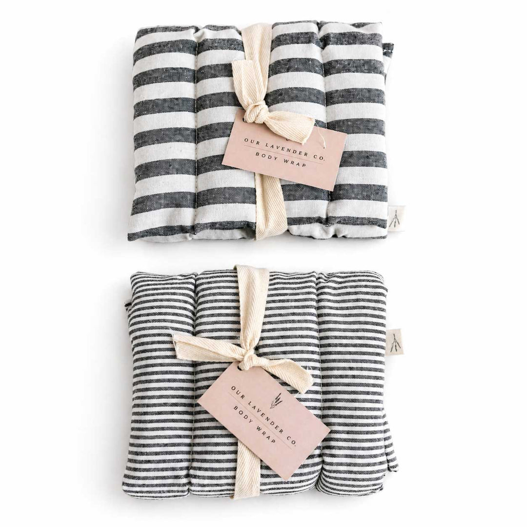 Two striped body wraps with ribbons and tags on a white background