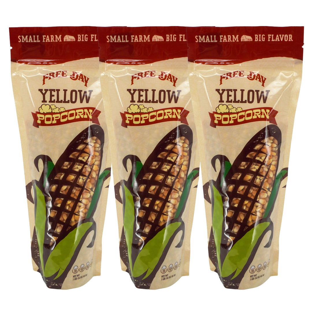 Three packages of Free Day Yellow Popcorn with corn illustrations on a white background
