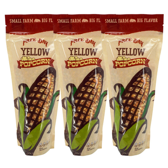 Three packages of Free Day Yellow Popcorn with corn illustrations on a white background