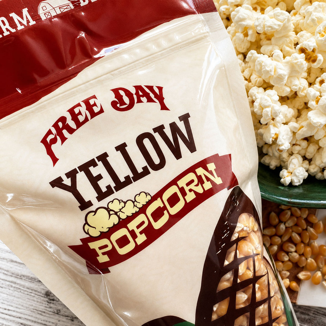 Bag of 'Free Day Yellow Popcorn' with popcorn and kernels on a wooden surface