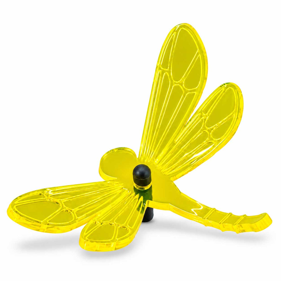 A translucent neon yellow dragonfly-shaped wind spinner with a black central hub and support post, shown on a clean white background.