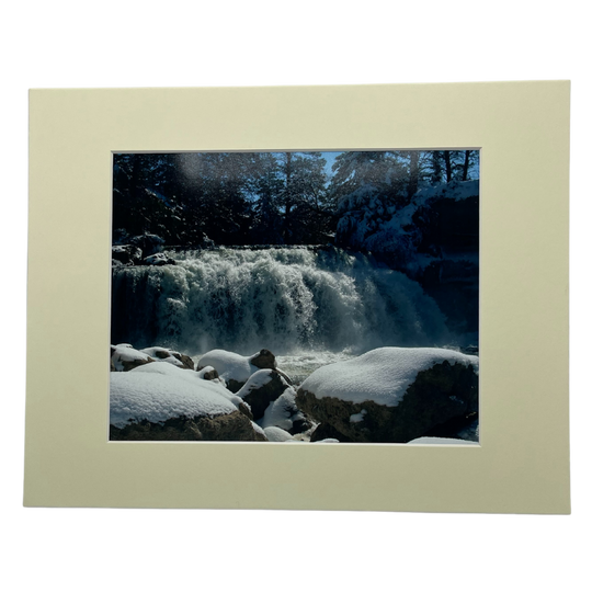 Photograph Of A Waterfall Behind Large, Snow-Covered Rocks With A Cream Colored Border