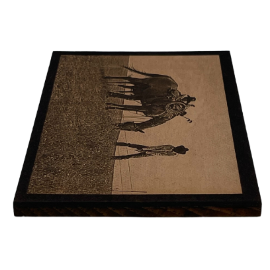 A Side Angle Of A Wood Printed Photograph Of Two Cowboys Playing Golf In A Field Alongside A Grazing Horse