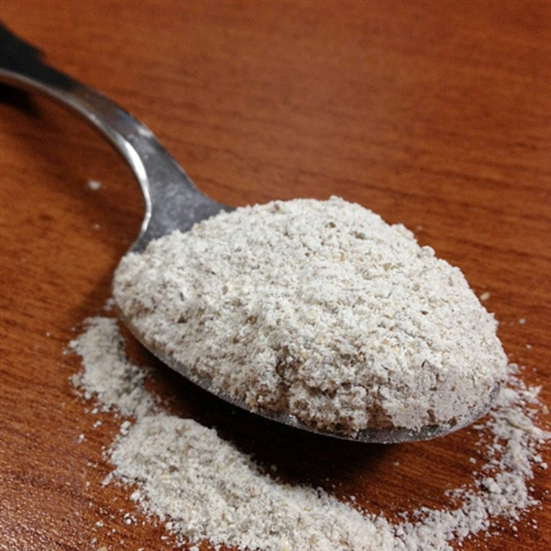 Spoonful Of Organic Rye Flour On A Wooden Table