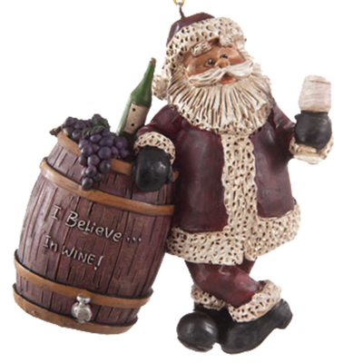 Ornament of Santa holding a wine glass and leaning on a wine barrel that has a bottle of wine , bunch of grapes sitting on top, shown on a white background