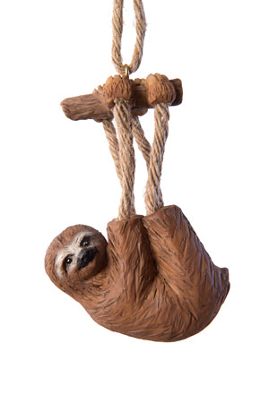 Ornament of a sloth hanging from a piece of tree branch and having jute-rope legs, shown on a white background